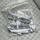 Plastic model parts in a clear bag on a grid surface